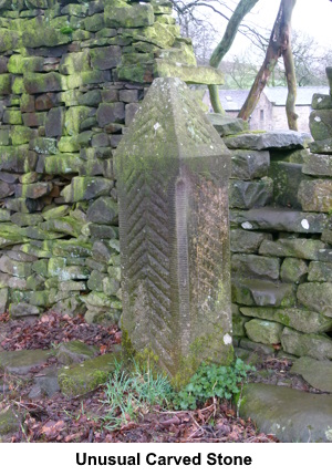 An unusual carved stone by a stile.