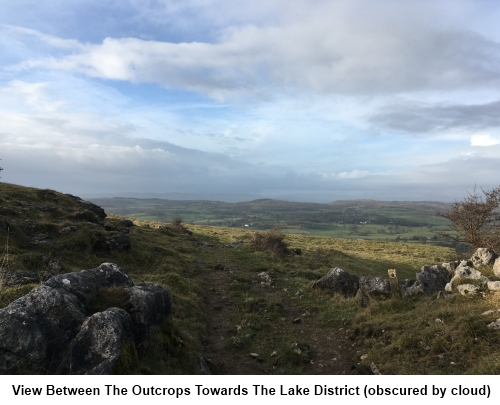 The view between the rocky outcrops mentioned in the text towards the Lake District, rather obscured by cloud.