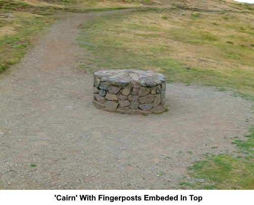 The stone "cairn" with fingerposts embedded in the top.
