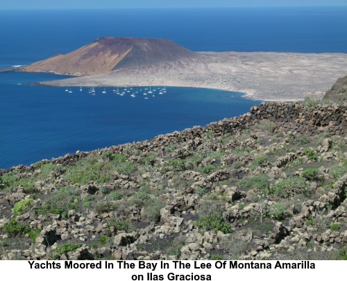 Yachts moored in the bay in the lee of Montana Amarilla.